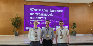 Clemens Balke, Marius Dellbrügge und Janis Purk stehen vor einer großen Anzeige, die auf die WCTR 2026 verweist.