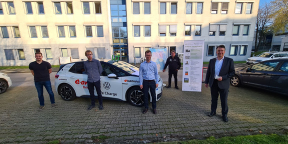 Gruppenfoto vor einem Elektroauto