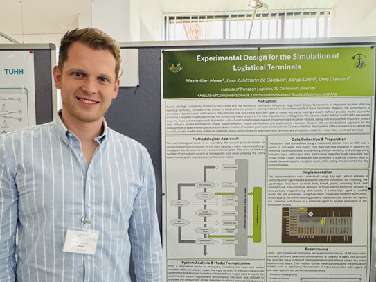 Maximilian Mowe steht vor einem Poster an einer Leinwand
