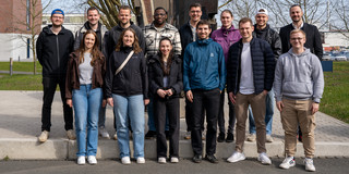 Die Mitarbeiter des ITL stehen vor einer Skulptur mit Herrn Michalski und machen ein Gruppenfoto