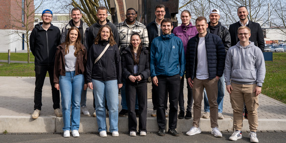 Die Mitarbeiter des ITL stehen vor einer Skulptur mit Herrn Michalski und machen ein Gruppenfoto