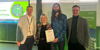 Dr. Ivo Hedtke, Aleksandra Grochala, Niklas Jost und Marius Dellbrügge stehen zusammen und zeigen eine Auszeichnung
