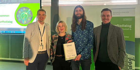 Dr. Ivo Hedtke, Aleksandra Grochala, Niklas Jost und Marius Dellbrügge stehen zusammen und zeigen eine Auszeichnung