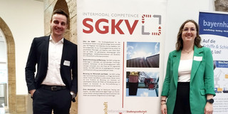 Marius Dellbrügge und Franziska Rosenthal stehen vor einem Aufsteller mit Werbung für den KV-Kongress